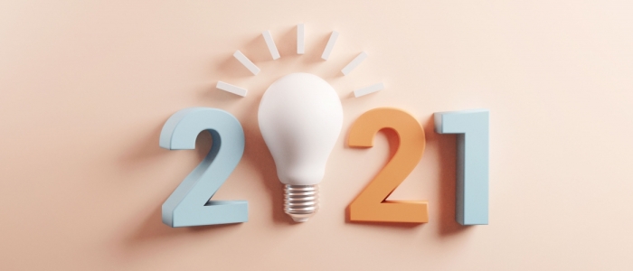 Text reads 2021 in front of a pink background. The 0 is a lightbulb.